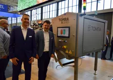 Kris de Smet en Karel Strubbe van Tomra Processed Food. Ze staan bij de nieuwe Tomra 5C. Deze machine is ontwikkeld om giftig onkruid tussen de groenten en fruit vandaan te halen. Verder vierde het bedrijf op de beurs haar 50ste verjaardag en werd de nieuwe marketingstrategie onthuld.